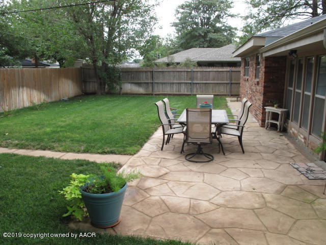 3305 Bedford Road Amarillo, TX 79106 - Photo 9 of 21 a view of a patio with table and chairs potted plants and a large tree