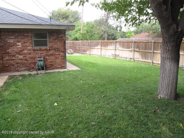 3305 Bedford Road Amarillo, TX 79106 - Photo 10 of 21 a view of a backyard with a small cabin and a large tree