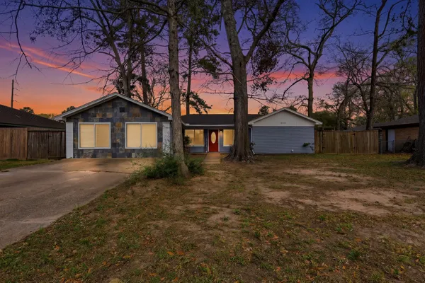 a front view of a house with a garden and tree