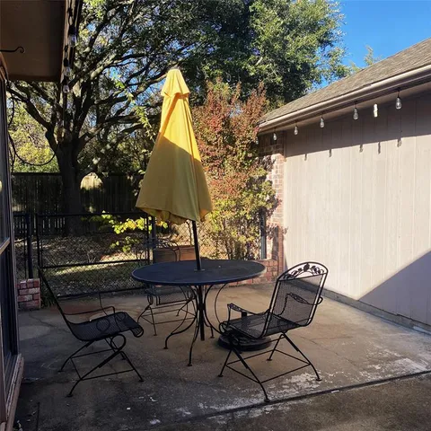 a backyard of a house with table and chairs