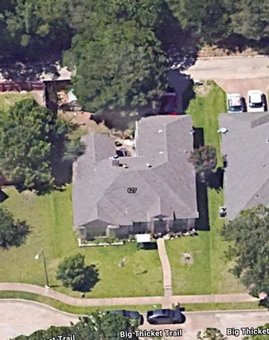 an aerial view of a house with a garden and lake view