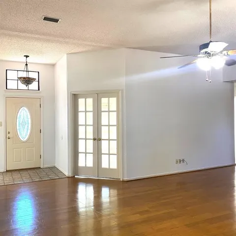 a view of empty room with wooden floor