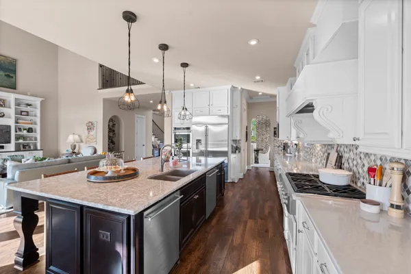 a kitchen with a stove and a wooden floor
