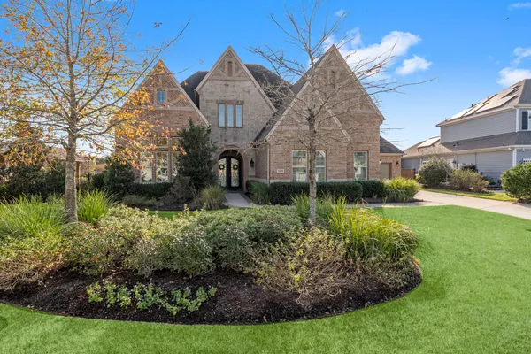 a view of a house with a yard and potted plants