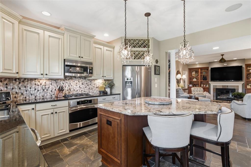 4502 Senate Court Valencia, PA 16059 - Photo 22 of 49 a kitchen with stainless steel appliances granite countertop a stove a refrigerator a kitchen island a sink a dining table and chairs