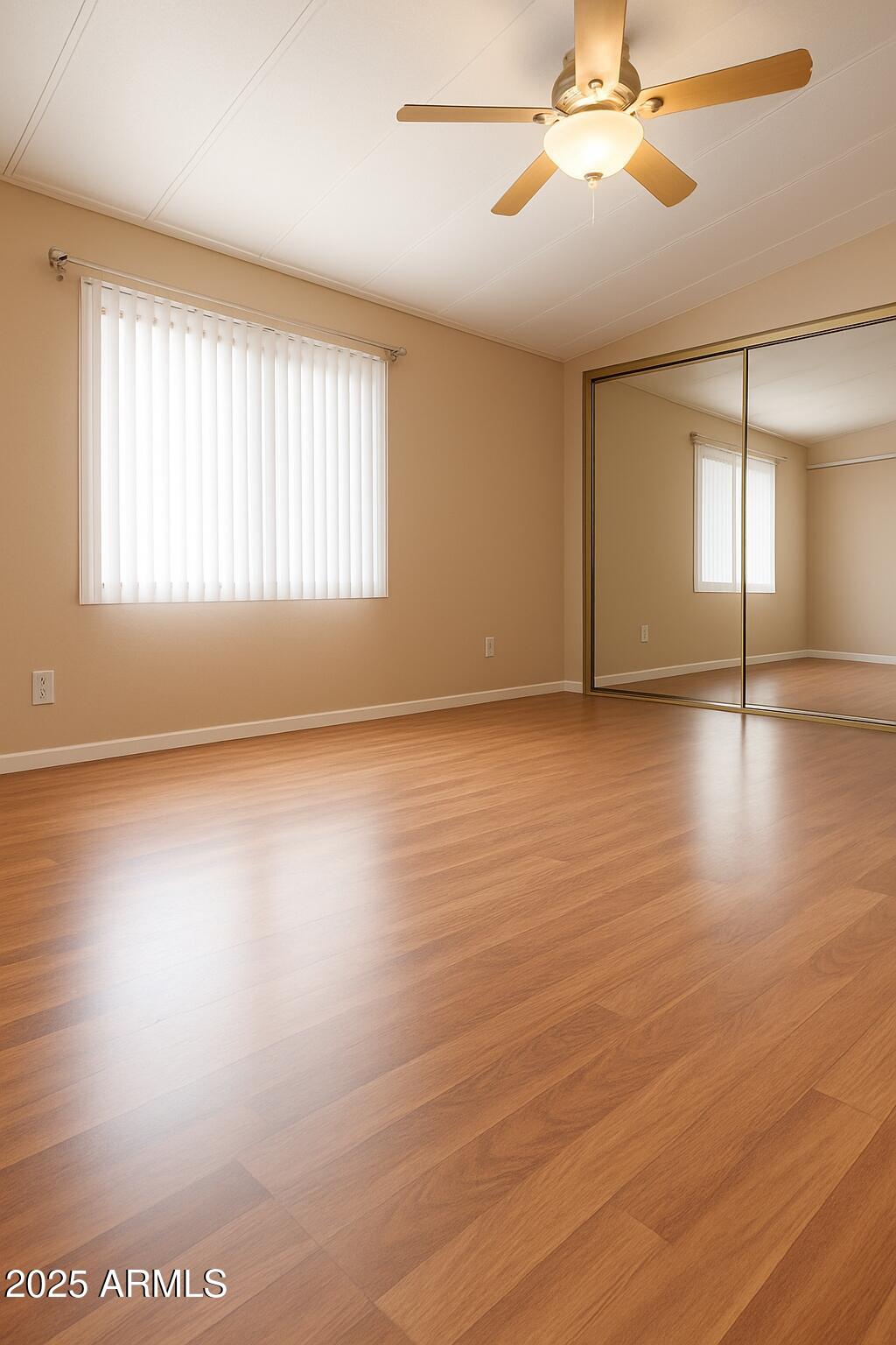 8600 East Broadway Road, Unit 55 Mesa, AZ 85208 - Photo 6 of 14 an empty room with wooden floor fan and windows