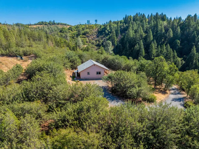 a bird view of a house with a yard and green space