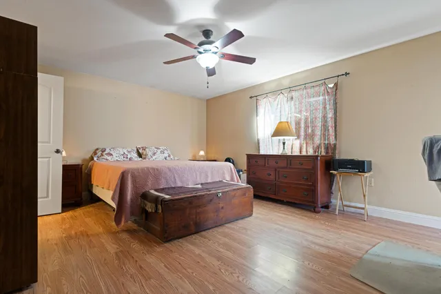 a spacious bedroom with a bed and wooden floor