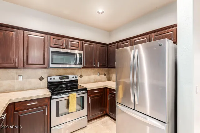 a kitchen with stainless steel appliances granite countertop a refrigerator sink and microwave
