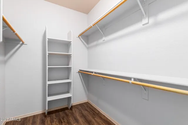 an empty room with closet and windows