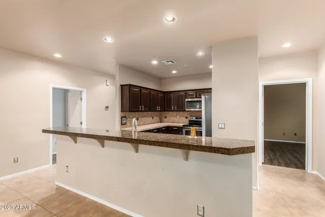 a view of a kitchen with stainless steel appliances wooden cabinets and a counter top space