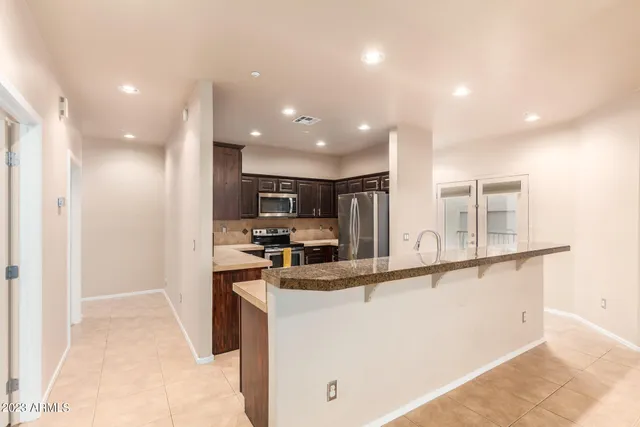 a kitchen with stainless steel appliances granite countertop a sink and a refrigerator