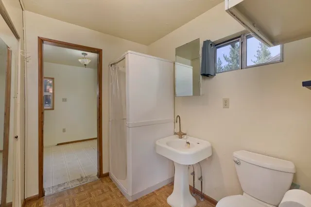 a bathroom with a sink mirror and toilet
