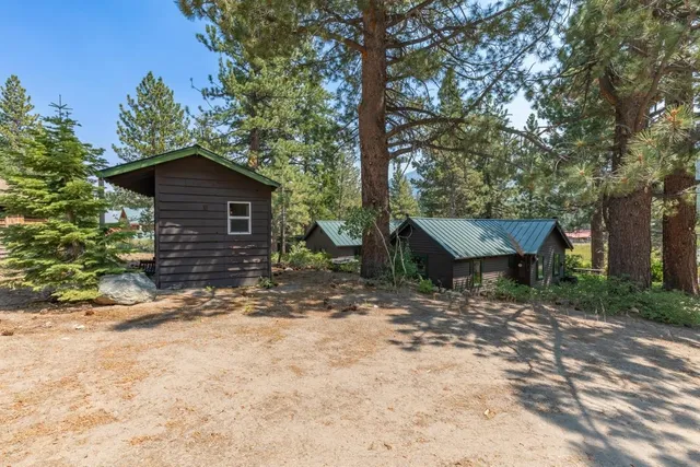 a view of a house with a yard and large tree