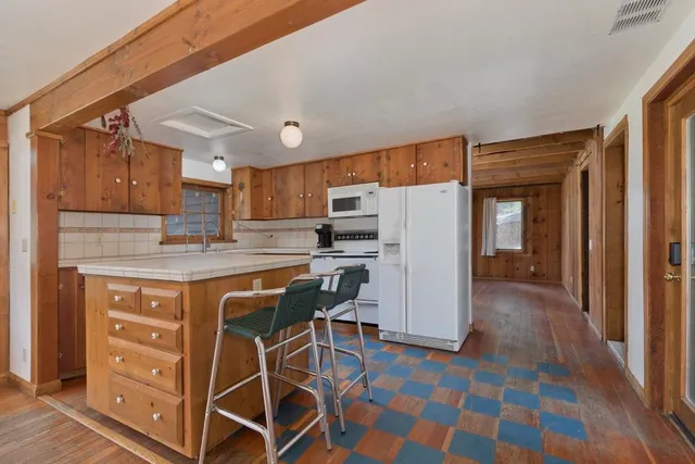 a kitchen with stainless steel appliances granite countertop a refrigerator and a stove top oven