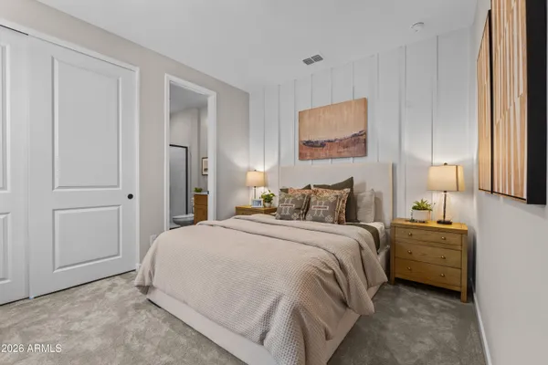 a spacious bedroom with a bed and a lamp