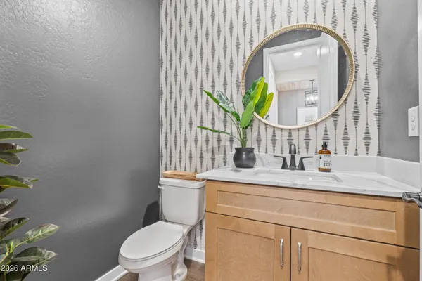 a bathroom with a granite countertop toilet a sink and mirror