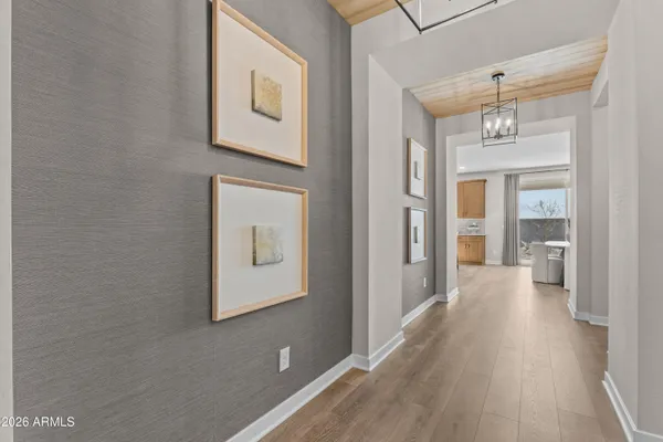 a view of a hallway with wooden floor and a bathroom