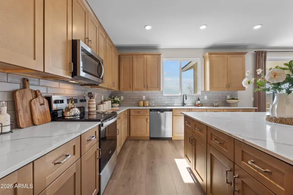 a kitchen with stainless steel appliances granite countertop a sink a stove and cabinets