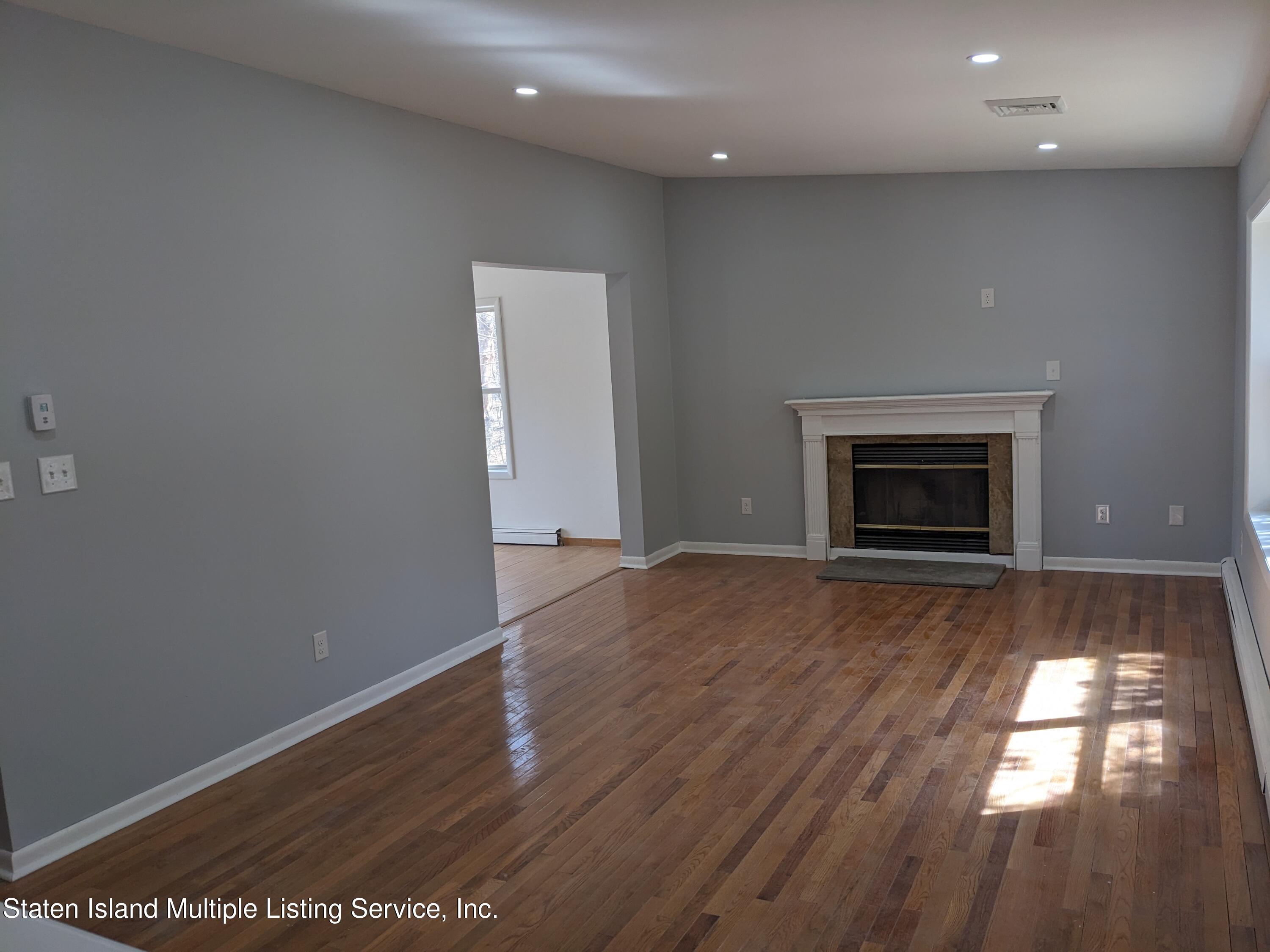 7609 Sawmill Road Pocono Lake, PA 18347 - Photo 18 of 47 an empty room with wooden floor fireplace and windows