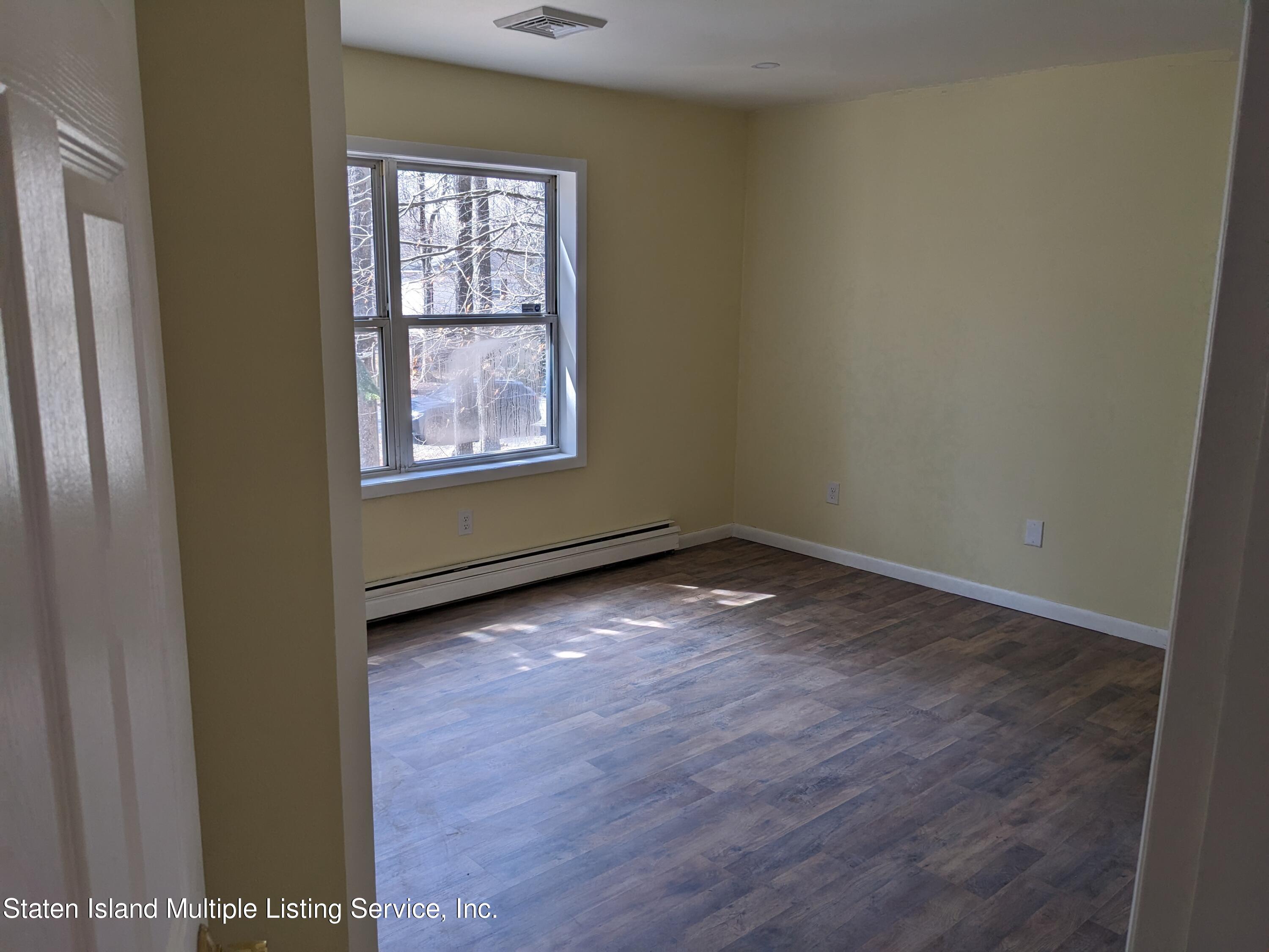 7609 Sawmill Road Pocono Lake, PA 18347 - Photo 32 of 47 an empty room with wooden floor and windows
