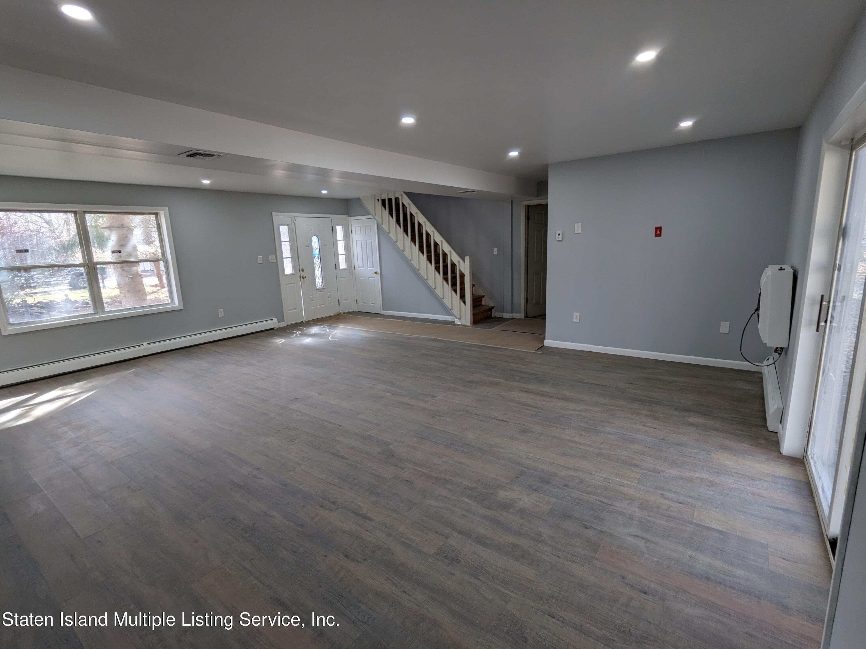 7609 Sawmill Road Pocono Lake, PA 18347 - Photo 9 of 47 an empty room with wooden floor and staircase