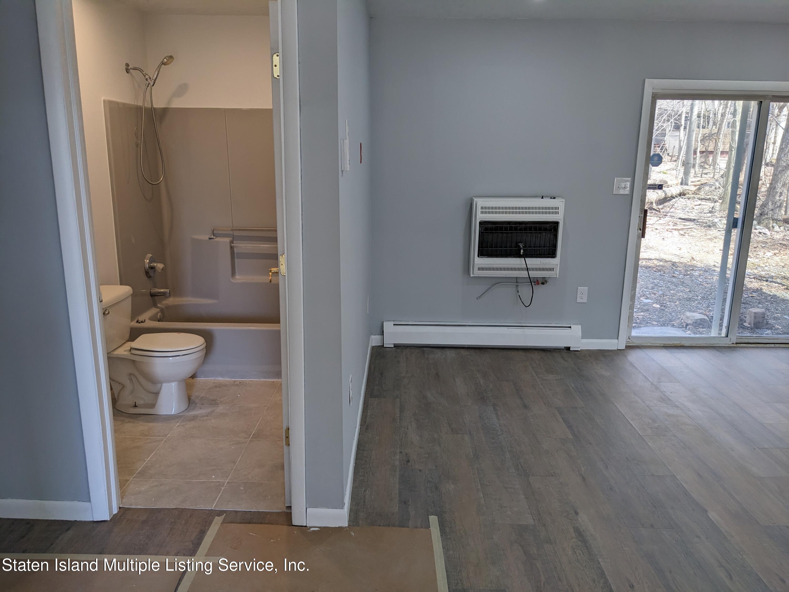7609 Sawmill Road Pocono Lake, PA 18347 - Photo 10 of 47 a view of a hallway with wooden floor and a bathroom