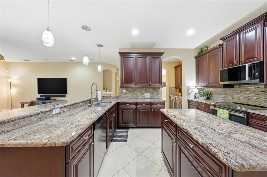 979 Counts Crest Circle Apopka, FL 32712 - Photo 13 of 48 a large kitchen with granite countertop a large counter top space appliances and cabinets