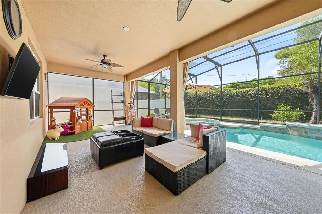 979 Counts Crest Circle Apopka, FL 32712 - Photo 18 of 48 a living room with furniture a flat screen tv and a floor to ceiling window