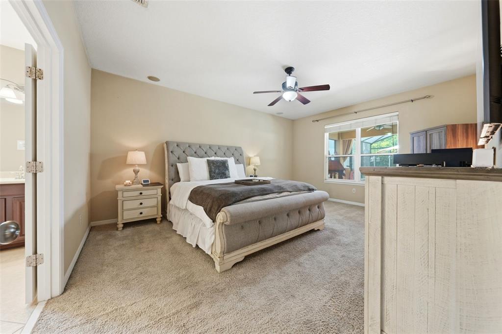 979 Counts Crest Circle Apopka, FL 32712 - Photo 25 of 48 a bedroom with a bed and a chandelier