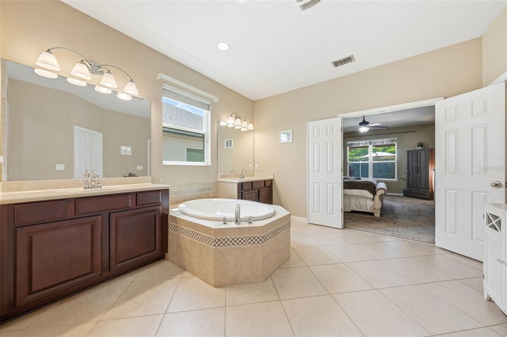 979 Counts Crest Circle Apopka, FL 32712 - Photo 28 of 48 a spacious bathroom with a double vanity sink a mirror and a bathtub