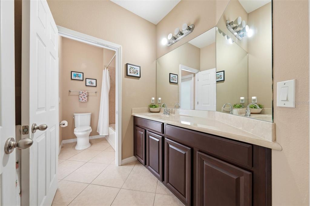 979 Counts Crest Circle Apopka, FL 32712 - Photo 33 of 48 a spacious bathroom with a granite countertop sink a toilet a large mirror and shower