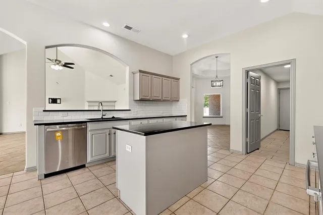 a kitchen with granite countertop a sink and a stove top oven