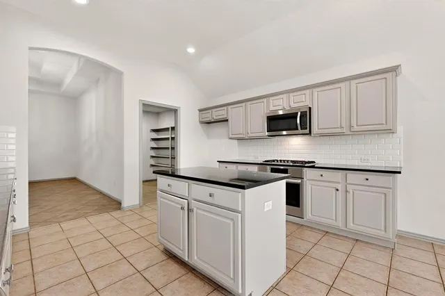 a kitchen with stainless steel appliances granite countertop a sink and a stove