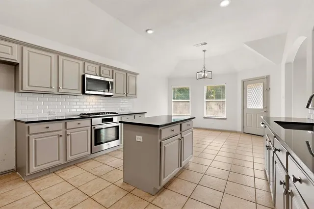 a kitchen with stainless steel appliances granite countertop a stove top oven a sink a counter top space and cabinets