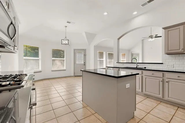 a kitchen with stainless steel appliances a sink stove and cabinets