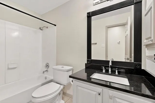 a bathroom with a granite countertop sink toilet a mirror and shower