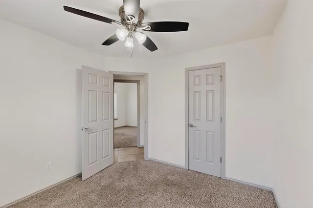 an empty room with chandelier fan