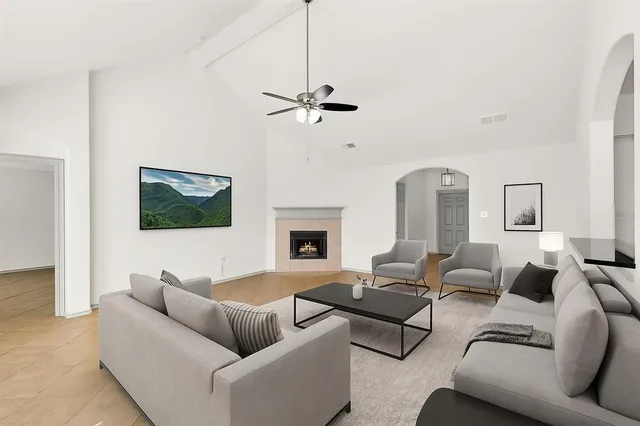 a living room with furniture ceiling fan and a fireplace