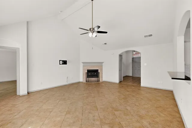 a view of a room with a ceiling fan and a fireplace