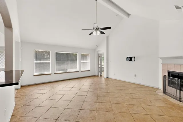 a view of an empty room with a fireplace and a window