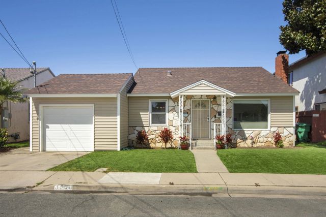 a front view of a house with a garden and plants