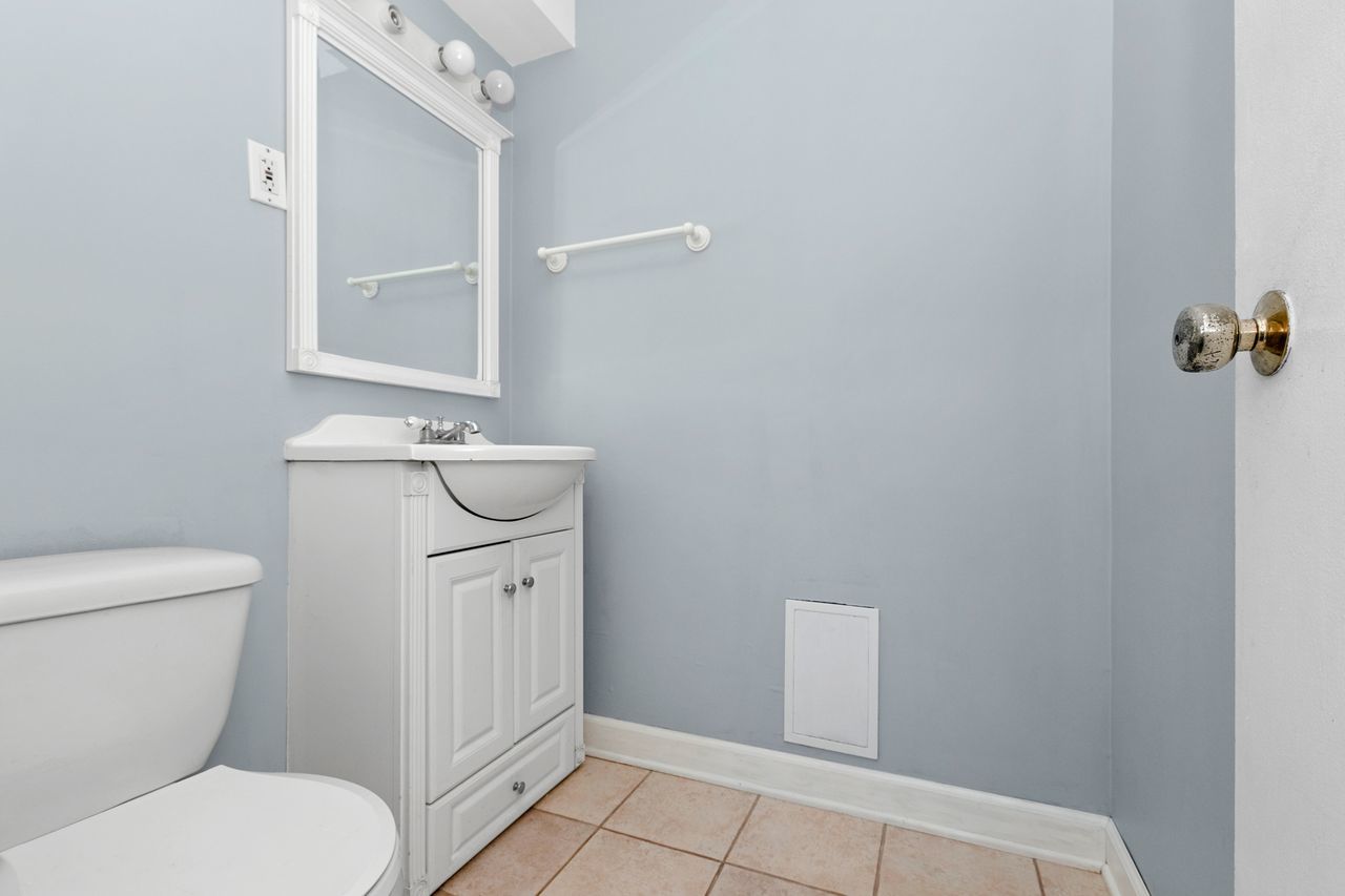 300 Indiana Street Park Forest, IL 60466 - Photo 21 of 26 a bathroom with a toilet a sink and mirror