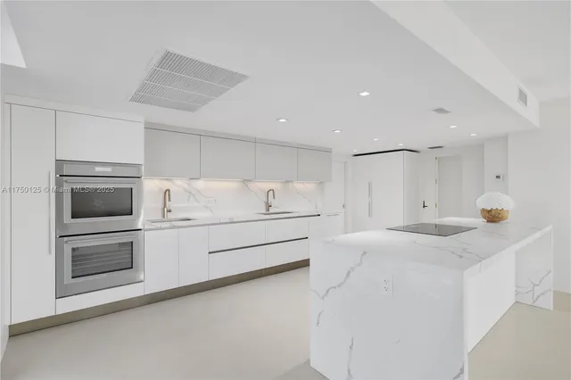a kitchen with stainless steel appliances white cabinets and wooden floors