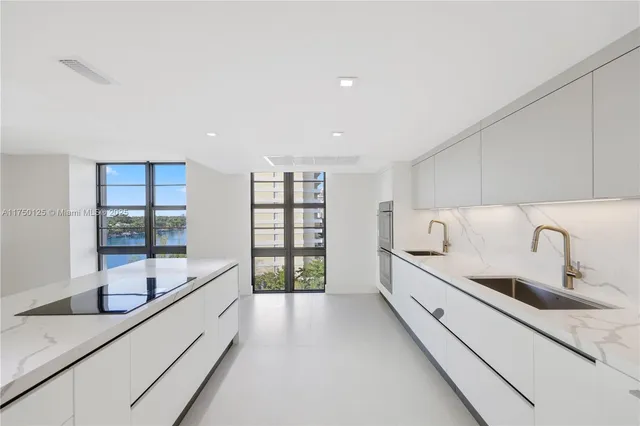 a large white kitchen with a large window