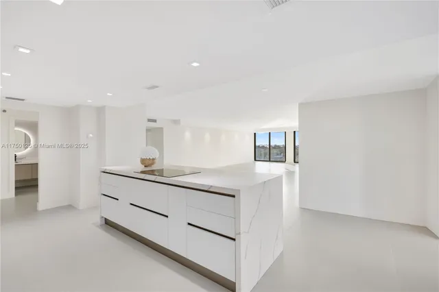 a kitchen with white cabinets and sink