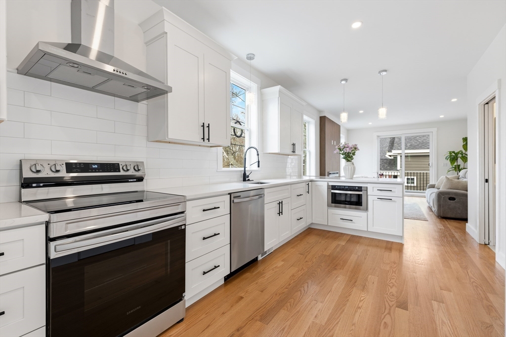2 Old County Road, Unit 14 Salisbury, MA 01952 - Photo 5 of 33 a kitchen with white cabinets stainless steel appliances and wooden floor