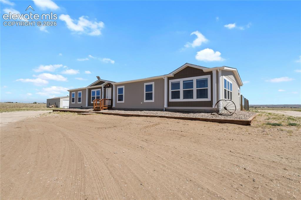 22280 Jones Road Peyton, CO 80831 - Photo 4 of 47 a front view of a house with a yard