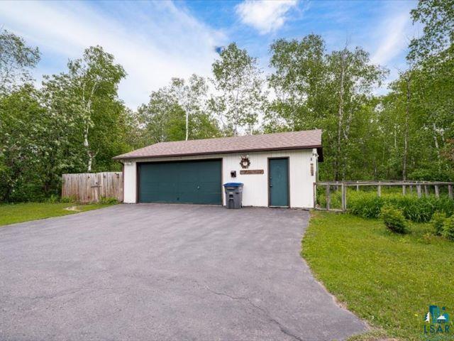 3616 Lavaque Road Hermantown, MN 55811 - Photo 16 of 43 Detached garage with a dark green overhead door, side entry door, and asphalt driveway