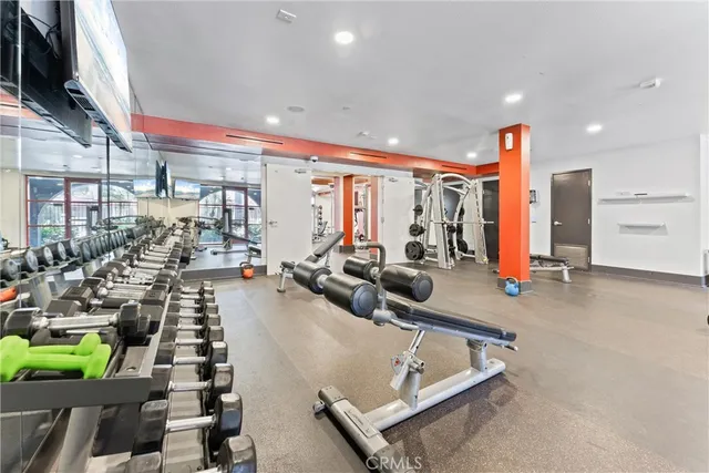 a view of kitchen with stainless steel appliances wooden floor and living room